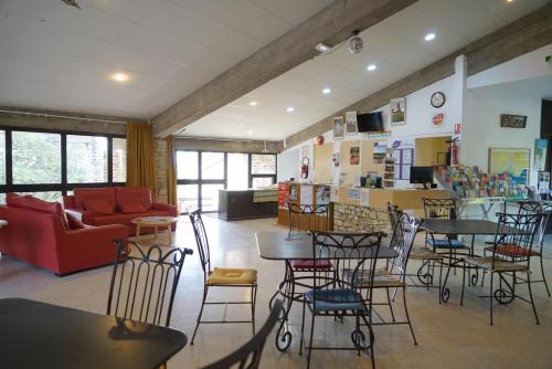 ein Restaurant mit Tischen und Stühlen und einer Couch in der Unterkunft VVF Luberon Provence in Murs