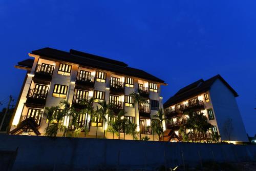 a large building with windows and plants in front of it at El Barrio Lanna in Chiang Mai