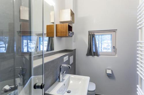 a white bathroom with a sink and a toilet at Zugspitz-Rauschen in Grainau