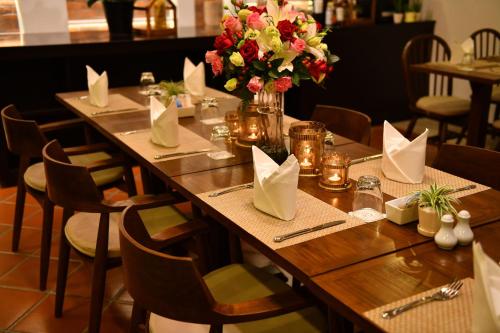 a table in a restaurant with flowers on it at El Barrio Lanna in Chiang Mai