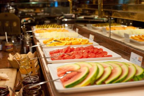 a buffet line with several trays of food with fruit at Vida Loca Sunset Beach Resort in Phu Quoc