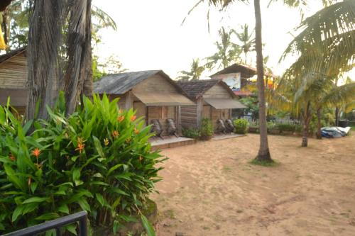 una casa en medio de un patio con árboles en O Camarao en Calangute