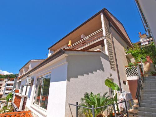 a white house with stairs and a balcony at Apartments and room Rabac 155 in Rabac