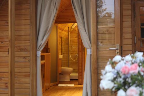 a bathroom with a toilet and a door with flowers at Vida Loca Sunset Beach Resort in Phu Quoc
