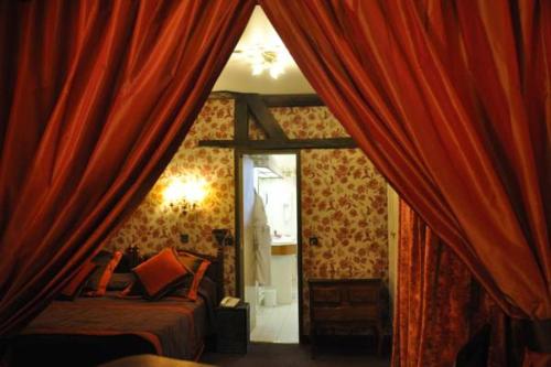 
a room with a bed, a mirror, and a window at Grand Hôtel Dechampaigne in Paris
