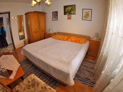 um quarto com uma cama com almofadas laranja em Apartments and room Rabac 155 em Rabac