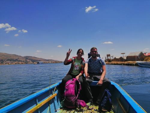 a man and a woman sitting in a boat on the water at Urosfood & Titiqaqa Lodge in Uros