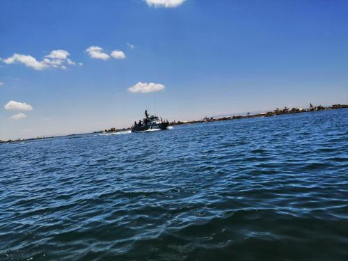 a boat in the middle of a large body of water at Urosfood & Titiqaqa Lodge in Uros