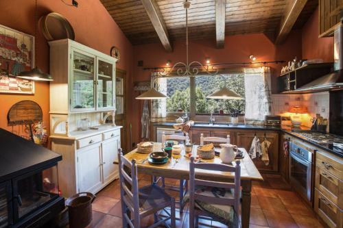a kitchen with a wooden table and a large window at Les Pedres in Camprodon
