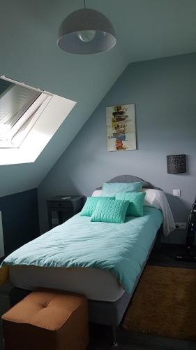 1 dormitorio con 1 cama con pared azul en nid cauchois en Betteville