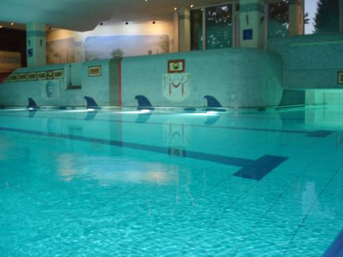 a swimming pool with blue water in a building at Ferienwohnung Bergpanorama mit Pool in Sankt Englmar