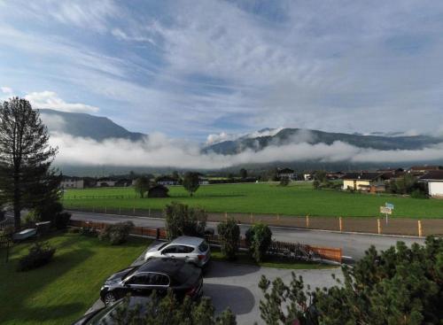 two cars parked in a parking lot in front of a mountain at Pension Stubachblick in Uttendorf