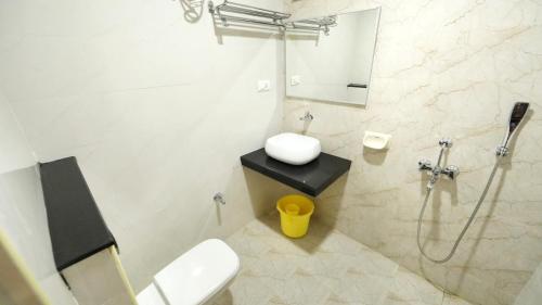 a bathroom with a shower and a toilet and a sink at Hotel Sri Ram Grand in Vijayawāda