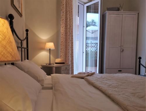 una camera da letto con un grande letto bianco e una finestra di Villa Toscana a Hajdúszoboszló