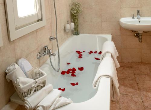 a bath tub sitting next to a bath tub sink at Hotel Porta Marmorea in Gubbio
