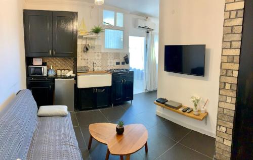 a kitchen with a couch and a table in a room at Shantell Luxury Apartment in Netanya