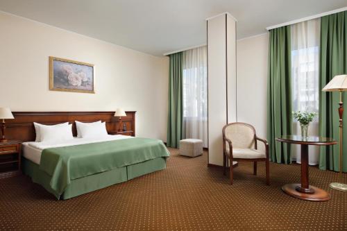 克拉斯諾達爾的住宿－Red Royal by Undersun，配有一张床和一把椅子的酒店客房