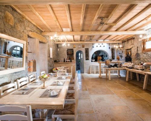 ein großes Esszimmer mit Holztischen und Stühlen in der Unterkunft Aletro Cottage Houses in Mykonos Stadt
