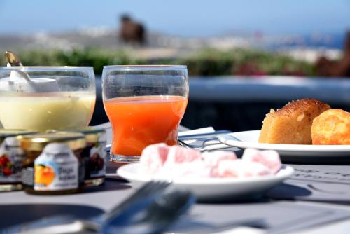 einen Tisch mit Speisen und Getränken in der Unterkunft Aletro Cottage Houses in Mykonos Stadt