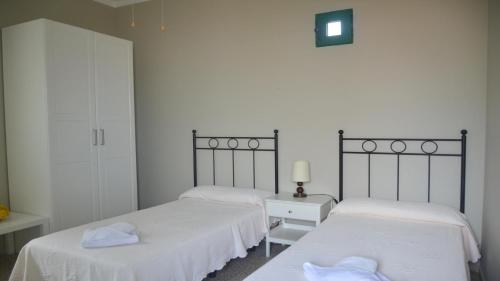 バジェ・グラン・レイにあるCasa Olivier La Playa bajoのベッドルーム1室(白いシーツが備わるベッド2台付)