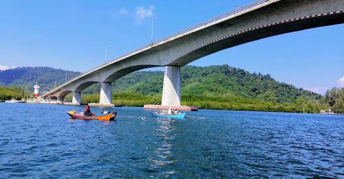 two boats in the water under a bridge at SER-EN-DIP-I-TY - SHA Extra Plus in Ko Lanta