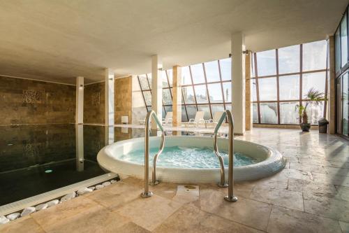 a large bathroom with a tub in a room with windows at Katalina SPA Resort in Tsigov Chark