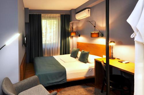 a hotel room with a bed and a desk at Elle Boutique Hotel in Tbilisi City