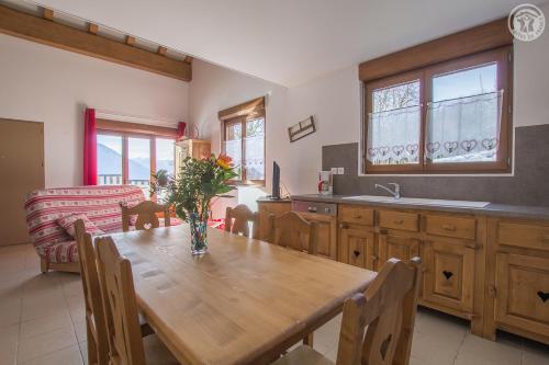 cocina y comedor con mesa de madera en Gîtes de la Bresse, en Saint-Georges-des-Hurtières