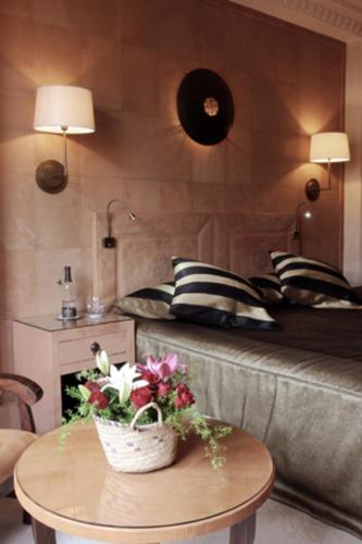 a living room with a bed and a table with flowers at La Maison Arabe Hotel, Spa & Cooking Workshops in Marrakech