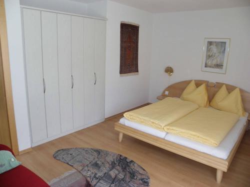 a bedroom with a bed with yellow sheets at Chasa Vaidum in Samnaun