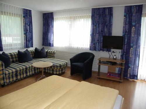a living room with a couch and a tv at Chasa Vaidum in Samnaun