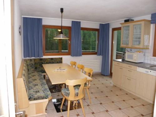 a kitchen with a table and chairs in a room at Chasa Vaidum in Samnaun
