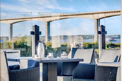 a table and chairs on a balcony with a view of a bridge at Hotel Pinenhus in Glyngøre
