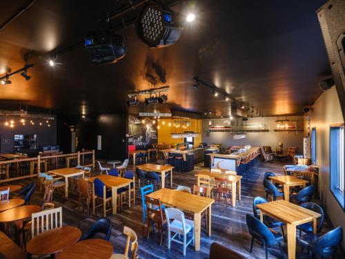 a restaurant with wooden tables and chairs at La Baleine Endiablée Microbrasserie in Rivière-Ouelle