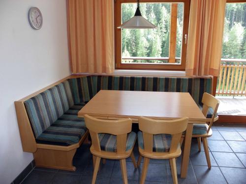 a dining room with a wooden table and chairs at Chasa Vaidum in Samnaun