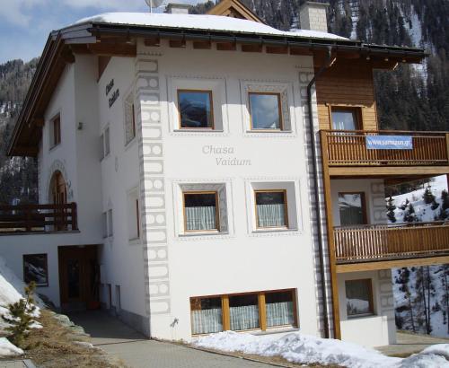 a large white building with a wooden balcony at Chasa Vaidum in Samnaun