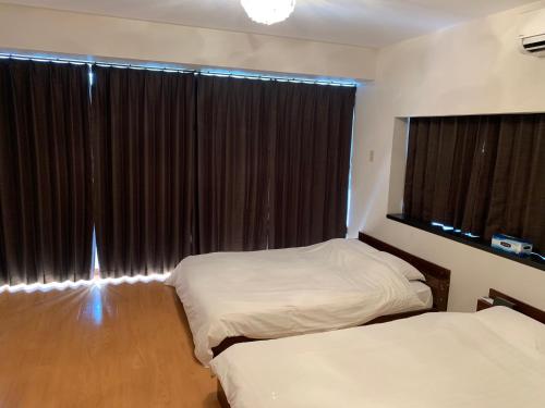 鹿児島市にあるガナダン中央駅 3f 無料駐車場のベッドルーム1室(ベッド2台、大きな窓付)
