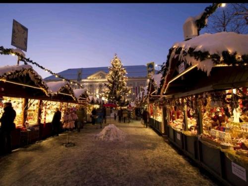 a christmas market in front of a building with a christmas tree at Alpe-Adria Apartments Chanel top12 in Oberaichwald