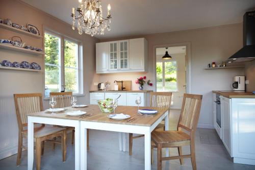 a kitchen with a table with chairs and a dining room at Red Haven Cottage in Edsbruk