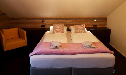 a pair of beds in a room with a chair at De Nussi's chalet 2 in Bach