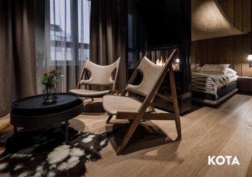 um quarto com três cadeiras, uma cama e uma mesa em HAAWE Boutique Apart Hotel em Rovaniemi