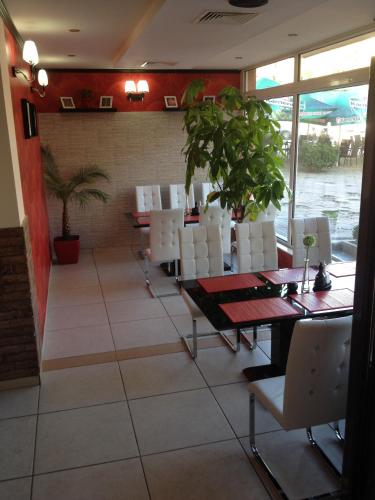 a dining room with a table and white chairs at Hotel Elena in Veliko Tŭrnovo