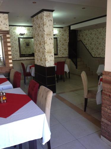 a restaurant with tables and chairs in a room at Hotel Elena in Veliko Tŭrnovo