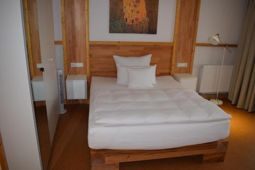 a bedroom with a large bed with white sheets at Apartmenthaus Erlenbach in Erlenbach