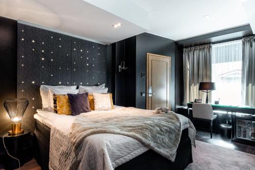 a bedroom with a large bed with a black wall at Arctic Light Hotel in Rovaniemi