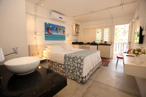 Un dormitorio con una cama y un baño con lavabo. en Saint Germain Kite Residence, en Icaraí