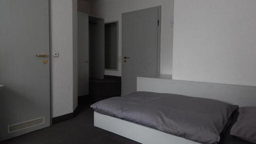 - une petite chambre avec un lit et un miroir dans l'établissement Hotel Carle, à Deizisau