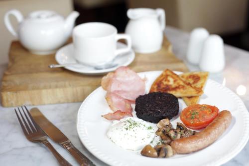 a plate of breakfast food with eggs sausage and toast at The Belhaven Hotel in Glasgow
