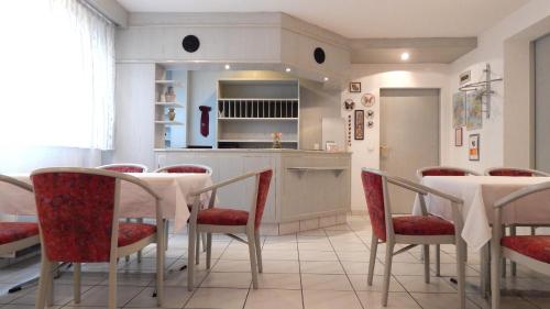 une salle à manger avec une table et des chaises rouges dans l'établissement Hotel Carle, à Deizisau