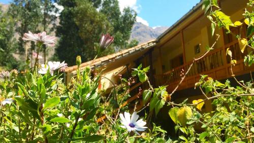 a building with flowers in front of it at Apu Lodge in Ollantaytambo